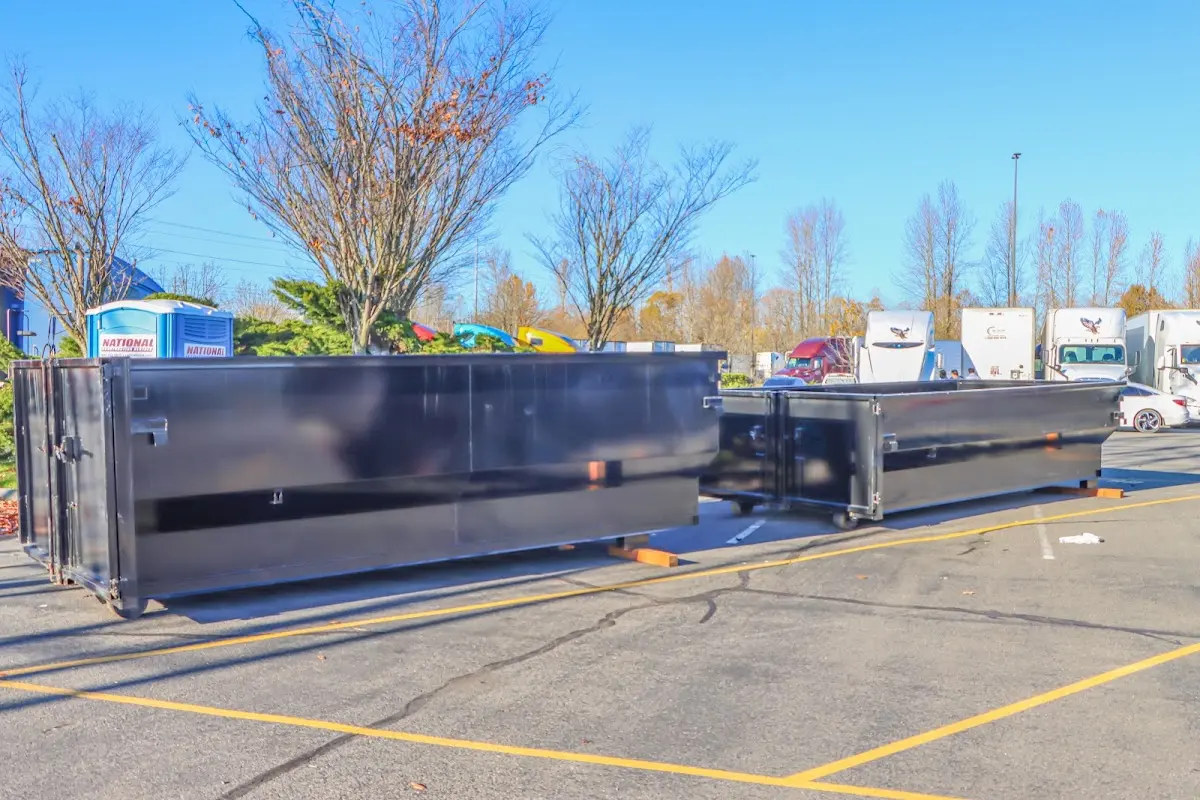 Professional dumpster rental service with roll-off container on residential driveway in Fort Lupton